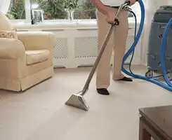 Carpet cleaning professional removing dirt and stains with a hot-water extraction tool in a home, Wichita, KS.